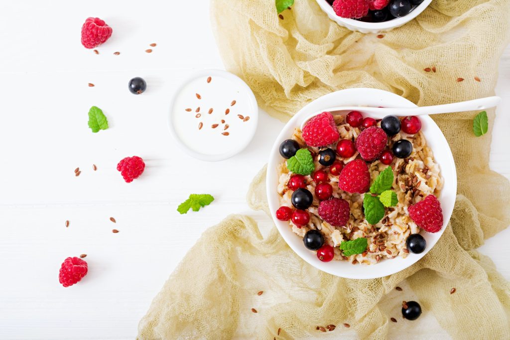 Tasty and healthy oatmeal porridge with berry, flax seeds and yogurt